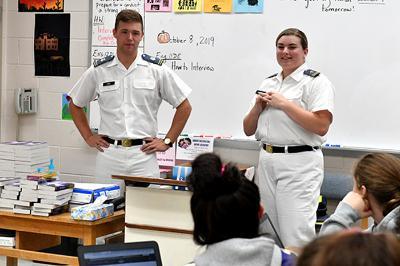 Kirk Ring 鈥�21 and Grace McDonald 鈥�21 are shown addressing students in a classroom.